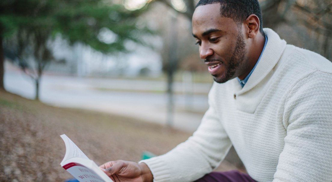 A man sitting in the park reading a book